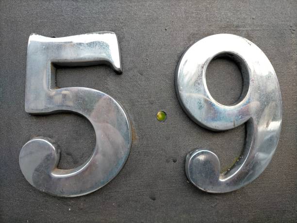istock Number fifty nine,59 in chrome colored number hooked on a black surface. 1426262850