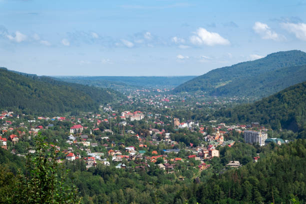 istock a town surrounded with a green forest and mountains 1426266842