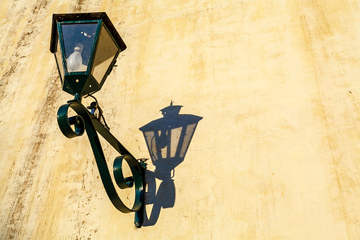 Old lantern with its shadow on the exterior wall of San Bernardo Monastery in the city of Salta, Salta Province, Argentina, South America