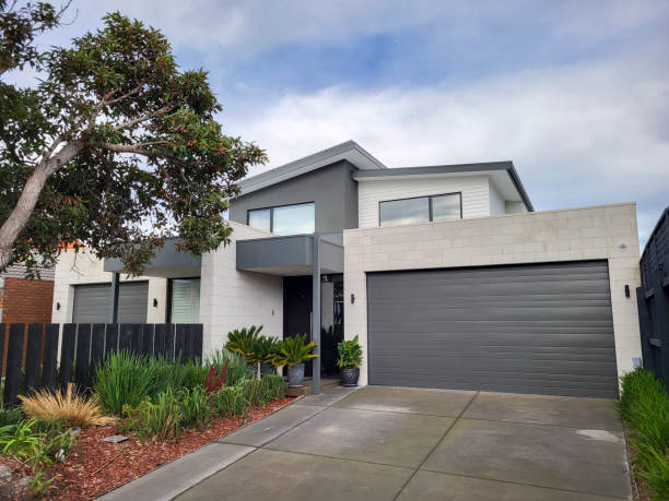 Modern semi-detached house with driveway. Melbourne, Australia: July 16, 2022: Modern semi-detahced house in the suburb of Chelsea with balcony, large double garage and landscaped garden to the front. australian culture stock pictures, royalty-free photos & images