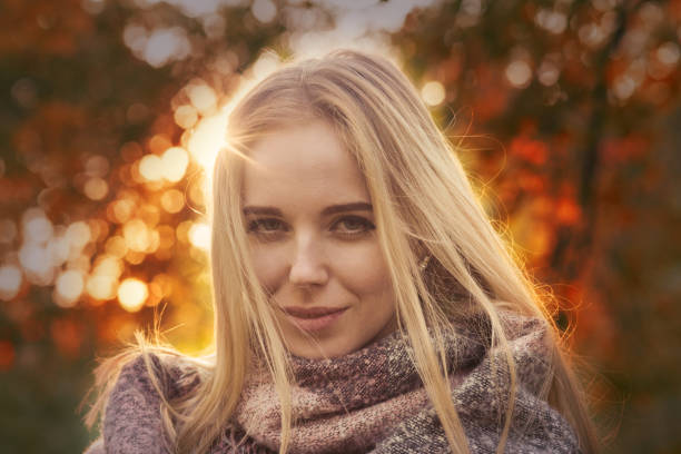 happy woman smiling in park at autumn sunset, toned image