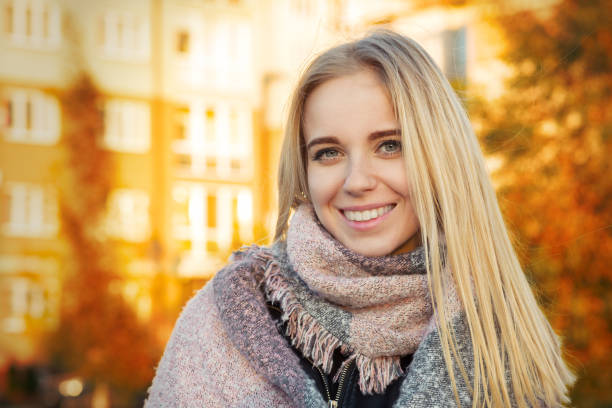 happy woman smiling in park at autumn sunset, toned image