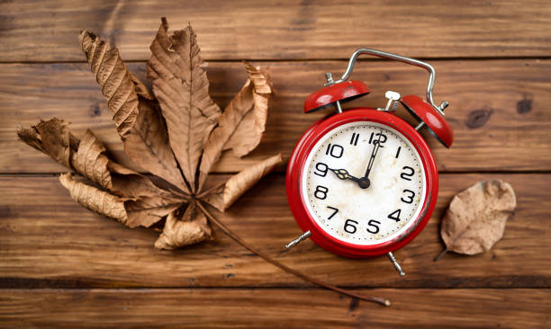 istock Alarm clock with autumn leaves, daylight savings time, fall background 1426274904