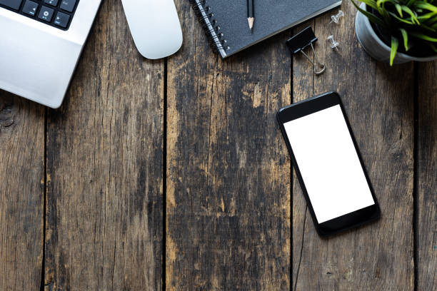 istock close up Blank Screen of Smartphone and Computer on Wooden Table top view. with clipping path 1426276110