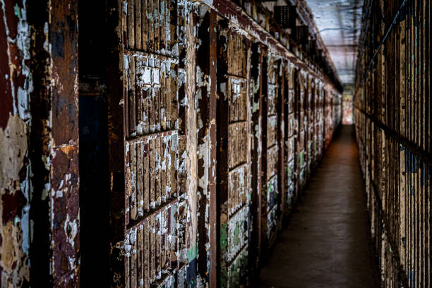 istock Old Dark Abandon Prison Cell Bars Hallway with Chipped with Flaking Paint in White Brown Black and Rust 1426280745