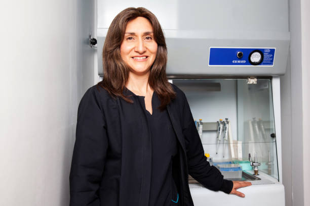 porträt einer wissenschaftlerin neben dem laminaren luftstromschrank im labor. - laminar flow cabinet stock-fotos und bilder