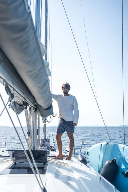 istock Young man prepares sail on mast at sea 1426287189