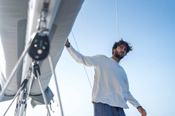istock Young man prepares sail on mast at sea 1426287212