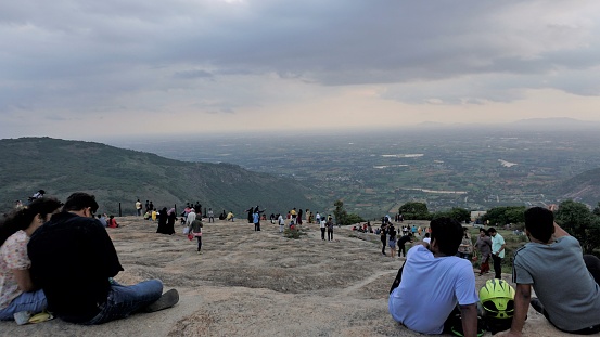 Nandi hills, Karnataka,India-May 22 2022: Tourists enjoying the beautiful scenic sunset from top of Nandi betta or Nandidurg. Top picnic spot and weekend gateway for bengalurians.