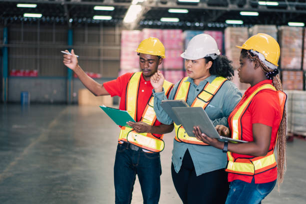 istock Group of African workers discussing work and checking stock with digital tablet in the warehouse factory. Logistic business teamwork at distribution center 1426293736