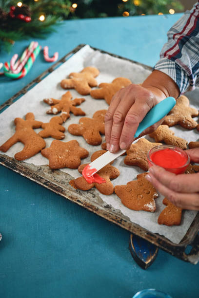 istock Decorating Gingerbread Christmas Cookies in Christmas Home Atmosphere 1426294819