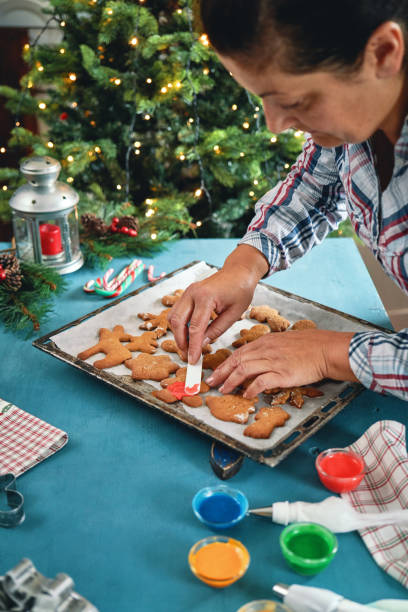 istock Decorating Gingerbread Christmas Cookies in Christmas Home Atmosphere 1426294889
