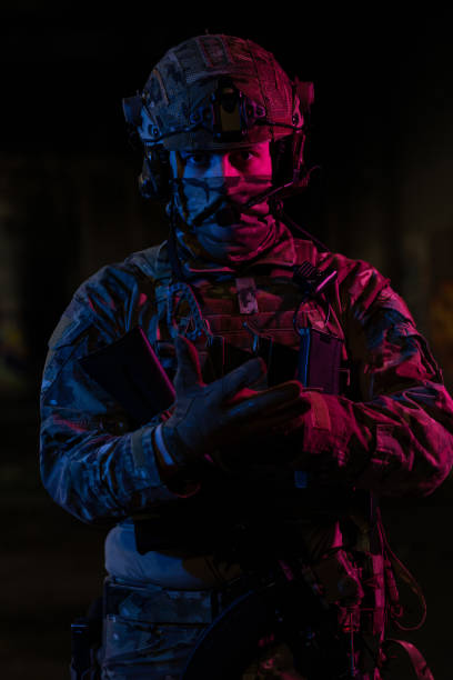 photo d’un soldat entièrement équipé en gilet tactique d’armure noire et gants debout sur fond noir vue de face. - black ops photos et images de collection