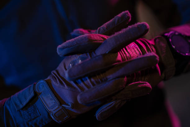 photo d’un soldat entièrement équipé en gilet tactique d’armure noire et gants debout sur fond noir vue de face. - black ops photos et images de collection
