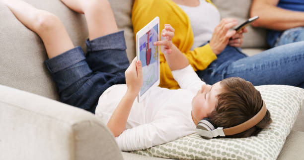 태블릿, 헤드폰 및 어린이 학습, 가족 가정, 휴가 또는 주말 방학에서 어린이 크리에이티브 앱에서 음악 및 디지털 그리기 듣기. 소파에서 소년과 함께 와이파이, 인터넷 및 온라인 청소년 게임 - six animals audio 뉴스 사진 이미지
