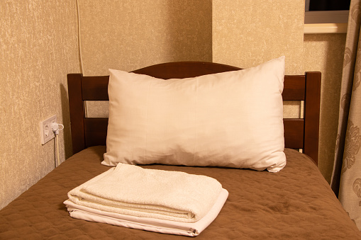 Single bed with white towels in the bedroom in the apartment building, bedroom furniture, bed and plaid