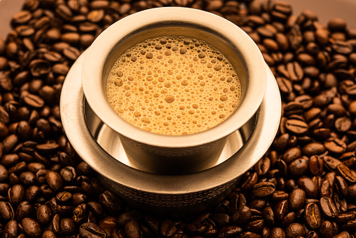 Coffee cup and coffee beans on wooden background. Top view.