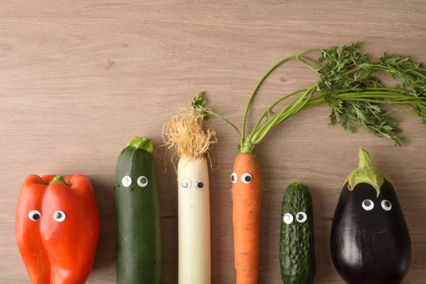 istock Background with funny vegetables with eyes on wooden table top 1426308032