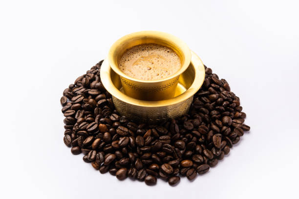 café filtre du sud de l’inde servi dans un gobelet traditionnel ou une tasse sur des grains crus torréfiés - soap sud photos et images de collection