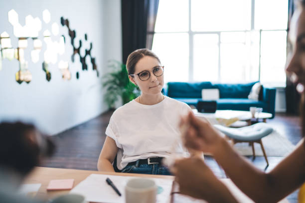 istock Serious young woman at table during brainstorm with colleagues 1426310671