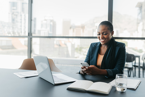 Business girl with phone typing during work break replying to email, sms message or networking via social media app. Communication, text conversation and black woman using smartphone for web search