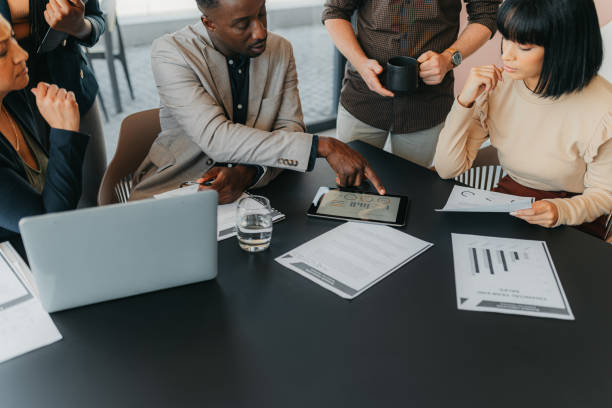 istock Leader, data and team at meeting with tablet analytics of sales chart, growth or global financial profit for franchise company. Business communication and teamwork at a market strategy collaboration 1426312118