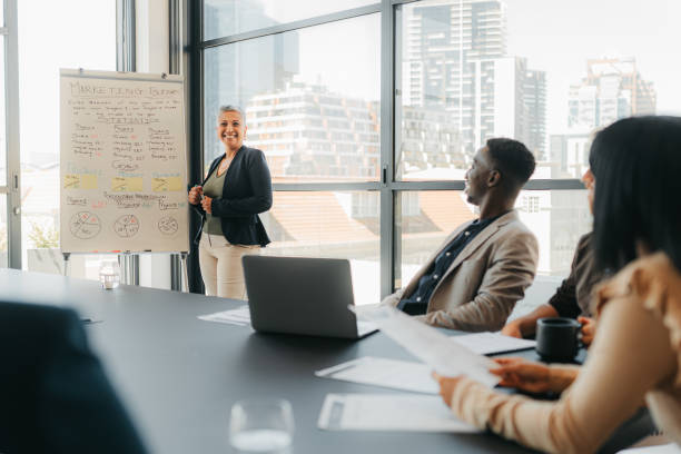 Presentation, leadership and training workshop with a manager, leader or CEO coaching staff during a boardroom meeting. Woman talking to employees about the company vision and mission development