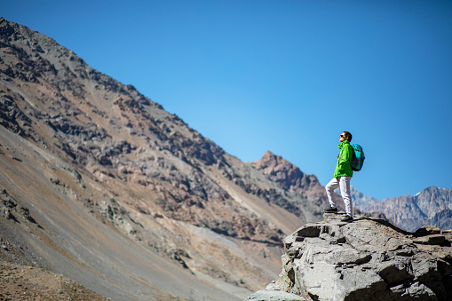 Image of a hiker contemplating the view of the mountains in The Andes, Chile.
