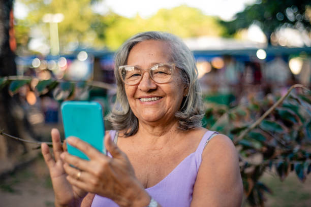 istock Gray-haired elderly woman using smartphone 1426317094