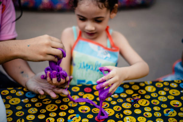 Purple slime. Child learning to make slime in a slime workshop. Focus on slime.