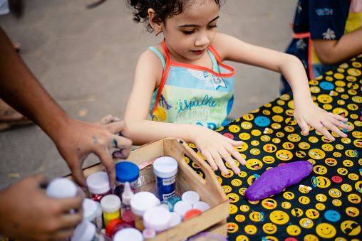 Purple slime. Child learning to make slime in a slime workshop. Focus on slime.