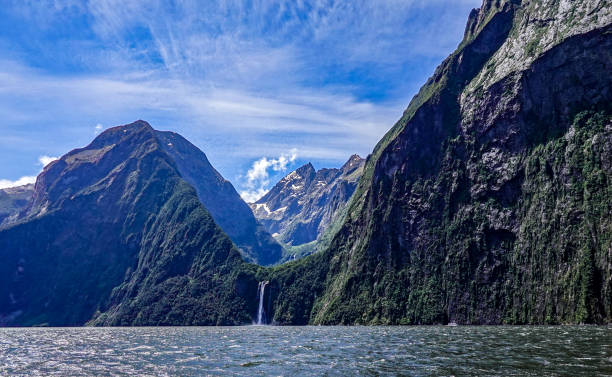Waterfall dropping into Milford Sound, New Zealand. stock photo
