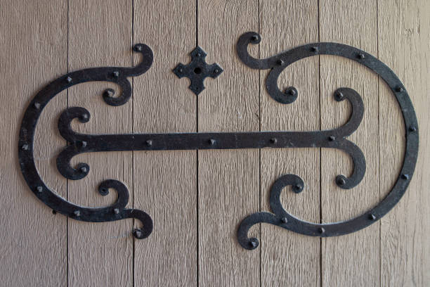 Detail of an old red wooden door with wrought iron decoration in the form of arabesques