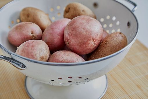 Potato in a bowl, on a kitchen table, vegan food preparation