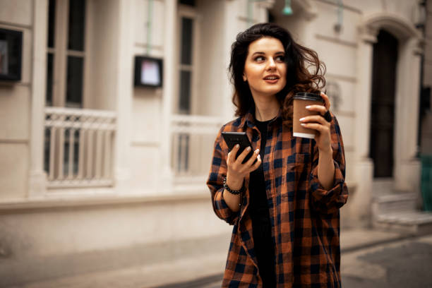 istock Beautiful woman using phone outside 1426328842