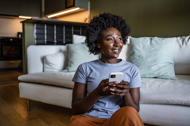istock Beautiful young woman using smart phone at home 1426333357