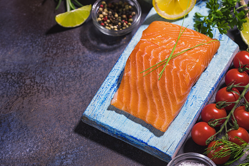 Fresh salmon fillet with herbs on the cutting board