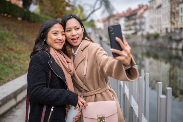 istock Smiling Female Friends Taking Selfie And Having Fun On Weekend 1426335675