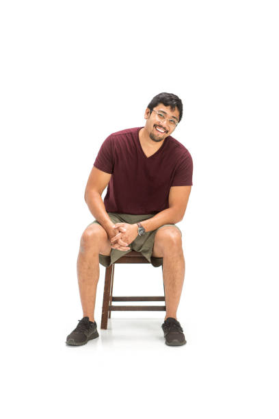 Laughing Asian Man Sitting on a Chair in Studio Shot