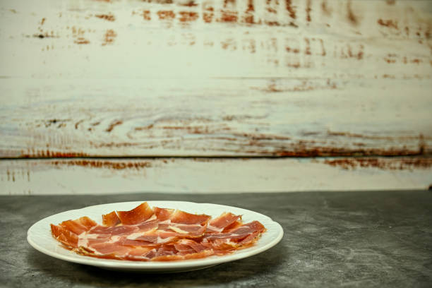 Plate of Serrano ham, freshly cut and served on a plate