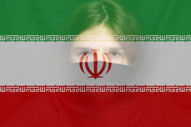 Defocus young woman, protest in Iran. Conflict war over border. Country flag. Woman low rights. Male hands.  Iranian women. Violence Iran women. Activism. Out of focus.