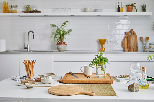 Modern white domestic kitchen, with fresh herbs, spices and seasoning, ready for a food preparation