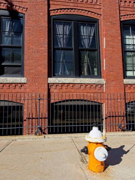 istock Repurposed brick mill building now apartments with sidewalk and fire hydrant in front 1426344731