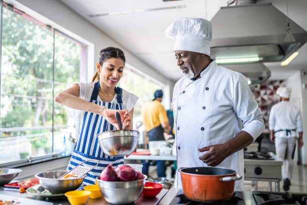 istock Student cooking and teacher helping in a cooking class 1426345945