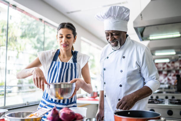 istock Student cooking and teacher helping in a cooking class 1426345999