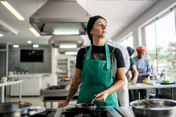 Contemplative mature woman cooking at the kitchen