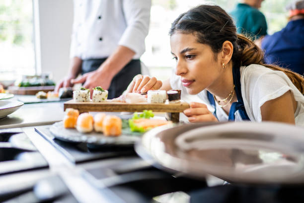 istock Young woman preparing sushis at the kitchen 1426346887