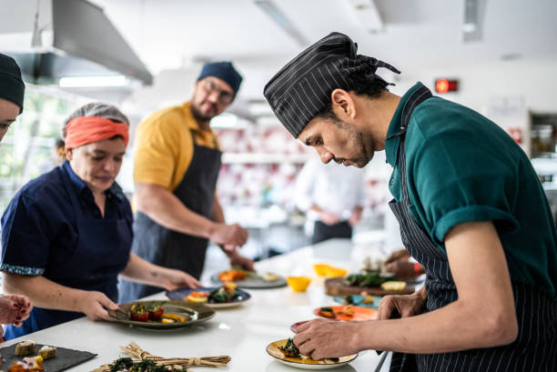 istock Man arranging food on a plate on a cooking class 1426348241