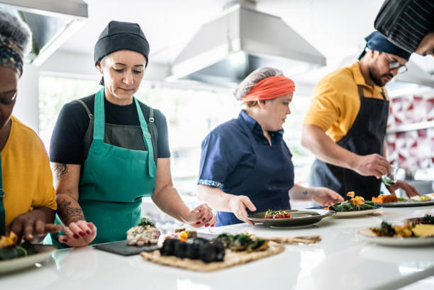 istock People arranging food on a plate on a cooking class 1426348478