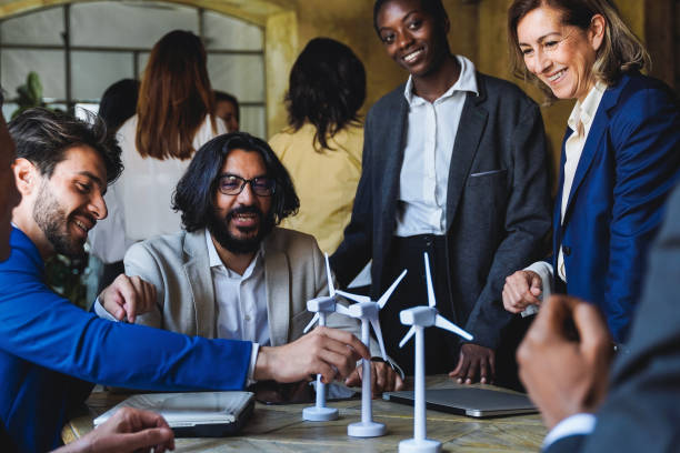 imprenditori multietnici che lavorano su un progetto di energia rinnovabile sostenibile all'interno dell'ufficio - concetto di elettricità alternativa verde - alternative enregy foto e immagini stock